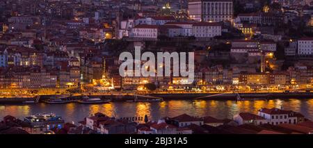 Historische Flussfront der Ribeira Region von Porto bei Dämmerung und Dom Luis I Brücke von Vila Nova de Gaia in Portugal Stockfoto