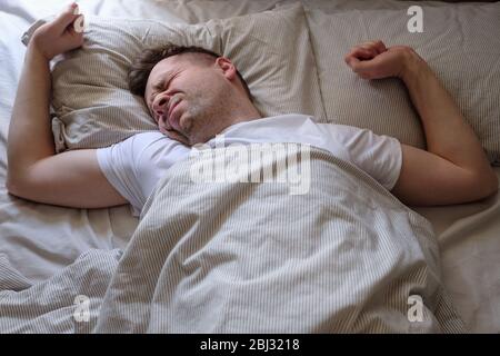 Junger Kaukasianer, der versucht aufzuwachen Stockfoto