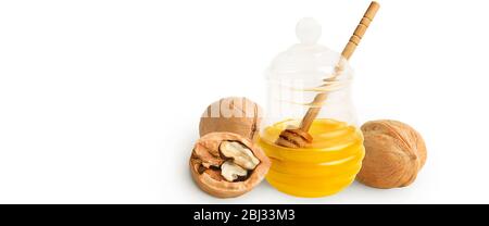 Natürlicher hausgemachter Honig in einem Glasgefäß mit Tropflöffel, mit ganzen und halben Walnüssen. Isoliert auf weißem Hintergrund mit einem Schatten. Stockfoto