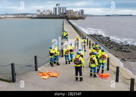 Mitglieder der Küstenwache während einer Trainingsübung an der Meeresmauer zum Marine Lake bei Weston Super Stute. Stockfoto