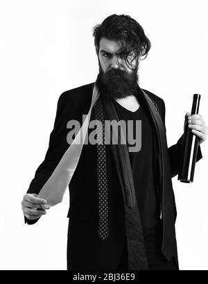 Bärtiger Mann, langer Bart. Brutaler kaukasischer Hipster mit Schnurrbart in schwarzem Anzug mit bunten Krawatten auf den Schultern, die Flasche auf weißem Studiohintergrund isoliert halten Stockfoto