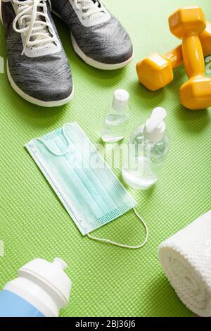 Medizinische Schutzmaske Desinfektions-Gelhandschuhe: Heim Fitness-Training Sneaker Hanteln und Schutzmaßnahmen gegen Viren, Bakterien Stockfoto