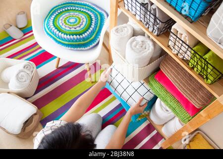 Bettwäsche, Bettbezüge und Handtücher werden vertikal gefaltet. Körbe aus Metall und Stoff schwarz. Bettwäsche in hellen Farben. Stockfoto