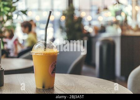 London/UK-1/08/18: Nahaufnahme eines Plastikglases Saft mit Stroh, stehend auf einem Tisch und kaufte im Joe & the Juice Cafe, das eine Kette von ist Stockfoto