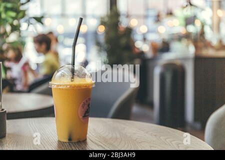 London/UK-1/08/18: Nahaufnahme eines Plastikglases Saft mit Stroh, stehend auf einem Tisch und kaufte im Joe & the Juice Cafe, das eine Kette von ist Stockfoto