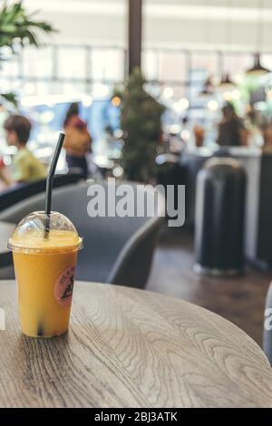 London/UK-1/08/18: Nahaufnahme eines Plastikglases Saft mit Stroh, stehend auf einem Tisch und kaufte im Joe & the Juice Cafe, das eine Kette von ist Stockfoto