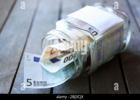 Einsparungen in Glas Bank auf Holzhintergrund Stockfoto