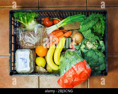 Obst- und Gemüsekiste mit lokalen Produkten aus einem Hofladen inklusive Eiern und Brot Stockfoto