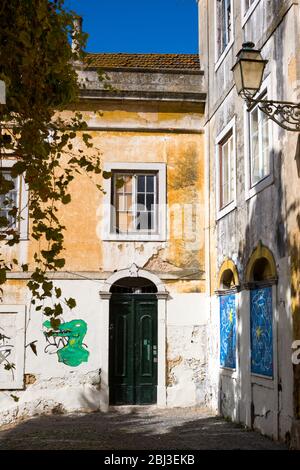 Graffiti und Straßenkunst an der bunten Wand traditioneller Architektur in Lissabon, Portugal Stockfoto