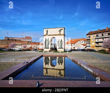 Landschaftsansicht mit Bogen Denkmal in Wasserbrunnen in einem Stadtplatz reflektiert, eatern europoean architetcural Wahrzeichen in Arad, Rumänien, aufgenommen am 03/ Stockfoto