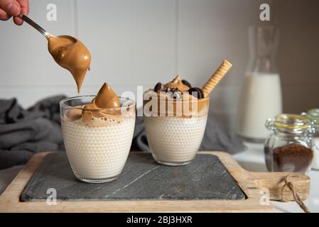 Dalgona Coffee – Kaffee oder Espresso-Pulver, mit Zucker und heißem Wasser geschlagenen. Eiskaffee, gepeitscht, Dalgona-Kaffee-Konzept. Stockfoto