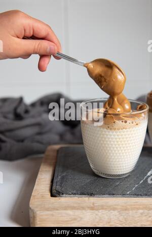 Dalgona Coffee – Kaffee oder Espresso-Pulver, mit Zucker und heißem Wasser geschlagenen. Eiskaffee, gepeitscht, Dalgona-Kaffee-Konzept. Stockfoto