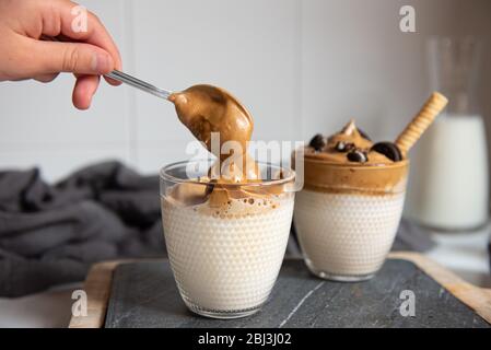 Dalgona Coffee – Kaffee oder Espresso-Pulver, mit Zucker und heißem Wasser geschlagenen. Eiskaffee, gepeitscht, Dalgona-Kaffee-Konzept. Stockfoto