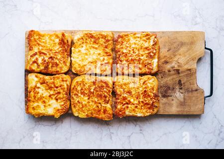 Sechs warme gegrillte Sandwiches mit geschmolzenem Mozzarella und Ei auf einem Holzbrett Stockfoto