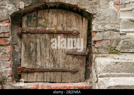 Alte rustikale Mittelalterholztür mit rostigen Metallscharnieren Stockfoto