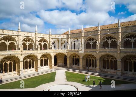 Touristen passieren Steinsäulen und Kreuzgänge des berühmten Klosters von Jeronimos - Mosteiro dos Jeronimos in Lissabon, Portugal Stockfoto