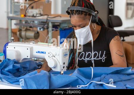 Detroit, Usa. April 2020. Detroit, Michigan - Arbeiter im Industrial Sewing and Innovation Center machen Isolationskleider für Beschäftigte im Gesundheitswesen. ISAIC ist eine neu eröffnete genähte Waren Herstellung und Ausbildung gemeinnützig. Es sollte Kleidung produzieren, aber aufgrund der Coronavirus-Pandemie wurde es zu Isolationskleidern verlegt. Kredit: Jim West/Alamy Live News Stockfoto