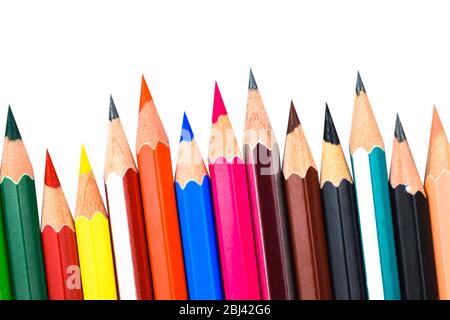 Verschiedene farbige Bleistiftstifte aus Holz in einer Reihe vor einem weißen isolierten Hintergrund platziert Stockfoto