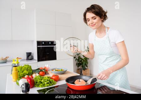 Foto von schönen fröhlichen Hausfrau Dame setzen frische rohe Lachs Filet großes Steak auf fliegende Pfanne genießen schönen Geruch halten Diät Kochen gesundes Abendessen Stockfoto