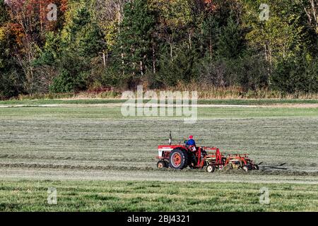 Landwirt auf Traktor Heuherstellung in Vermont. Stockfoto