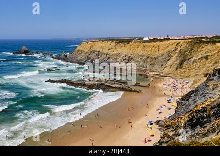 Strand und Klippe am Praia da Zambujeira do Mar. Solo Backpacker Trekking auf der Rota Vicentina und Fischerstoilpfad in Alentejo, Portugal. Gehwette Stockfoto