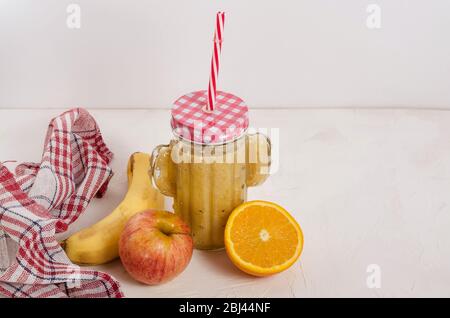 Obst-Smoothie aus frischen Zutaten aus Apfel, Banane, Orange auf weißem Holzhintergrund mit Kopierfläche. Gesunde Ernährung, Obst-Frühstück. Stockfoto