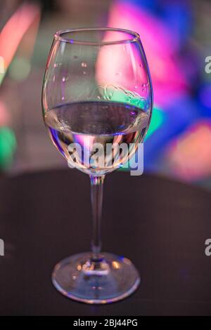 Glas Weißwein auf dem Tisch auf dem bunten Licht Hintergrund. Weißrussland, Minsk. Stockfoto