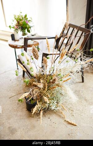 Brautgebühren Morgen zu Hause mit Hochzeit Accessoires und Blumenstrauß. Blumen, Einrichtung und Stuhl Stockfoto