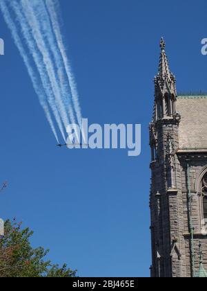 US Navy Blue Angels und US Air Force Thunderbirds über Newark, New Jersey USA am 28. April 2020 in einer Hommage an die Ersthelfer und die wichtigsten Arbeiter, die an der Front der Covid-19 Pandemie gewesen sind. Unter einem kristallklaren blauen Himmel werden die Flugzeuge über Newark, New Jersey's Sacred Heart Cathedral, gesehen, während sie nach Norden fahren. Insgesamt zwölf Flugzeuge gingen sekundenweit über die Stadt. Foto: Tom Cassidy/ Alamy Stockfoto