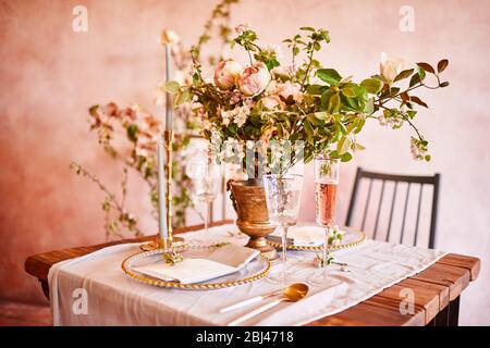 Festliche Tischdekoration. Goldenes Besteck. Mit verschiedenen natürlichen Farben und Blumen. Granat. Luxus Hochzeit, Party, Geburtstag. Blick von oben. Gold, rosa. Stockfoto