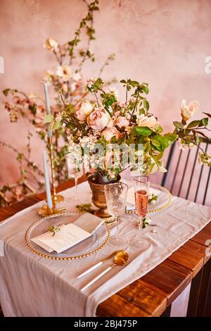 Festliche Tischdekoration. Goldenes Besteck. Mit verschiedenen natürlichen Farben und Blumen. Granat. Luxus Hochzeit, Party, Geburtstag. Blick von oben. Gold, rosa. Stockfoto