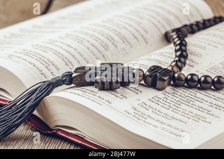 Bibel und ein Kruzifix auf einem alten Holztisch. Religionskonzept. Stockfoto