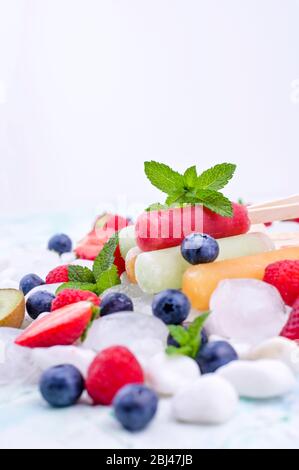 Hausgemachte Erdbeerpopsicles mit Eis, verschiedenen Beeren und Minze. Sommer gesundes Essen Konzept mit Kopierraum. Fruchteis mit verschiedenen Geschmacksrichtungen. Stockfoto