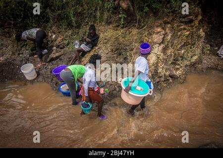 Nairobi, Kenia. April 2020. Junge Mädchen waschen ihre Kleidung an einem lokalen Fluss, ohne dabei soziale Distanz ohne Gesichtsmasken zu haben, um ihre Sicherheit gegen den Corona Virus zu gewährleisten. Kredit: Donwilson Odhiambo/ZUMA Wire/Alamy Live News Stockfoto