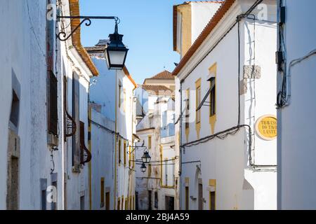 Typische weiße und gelbe Häuser in engen Gassen in Evora, Portugal Stockfoto