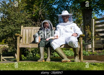 Camptoun, East Lothian, Schottland, Vereinigtes Königreich. April 2020. Eine Gemeinde im Lockdown: Bewohner einer kleinen ländlichen Gemeinde zeigen, wie das Leben im Lockdown für sie ist. Im Bild: Shane und sein Sohn Charlie, 9 Jahre alt, sind im zweiten Jahr der Bienenhaltung und hoffen, in diesem Jahr Honiggläser zu produzieren. Der Bienenstock enthält rund 20,000 Bienen Stockfoto