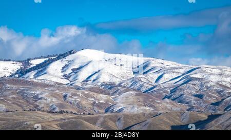 Leichter Schnee bedeckt teilweise die Ausläufer von Boise, Idaho an einem klaren Wintertag. Stockfoto