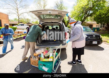 Sherman, TX / Vereinigte Staaten - 1. April 2020: Mitglieder der St. John's Christian Methodist Episcopal Church in Sherman, TX, veranstalten eine Drive-up-Speisekammer. Stockfoto