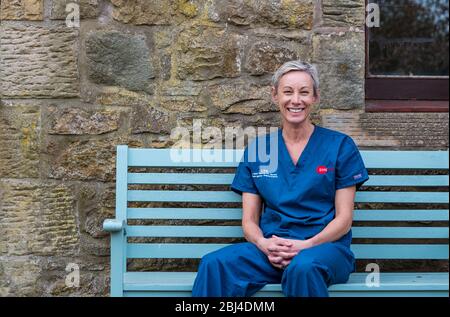 Camptoun, East Lothian, Schottland, Vereinigtes Königreich. April 2020. Eine Gemeinde im Lockdown: Bewohner einer kleinen ländlichen Gemeinde zeigen, wie das Leben im Lockdown für sie ist. Raphi ist eine NHS Krankenschwester, die derzeit am Royal Infirmary of Edinburgh lebt und weiterhin zur Arbeit geht. Sie zog vor kurzem ins Dorf und hat viel in ihrem Garten gearbeitet, wenn sie aus dem Dienst war Stockfoto