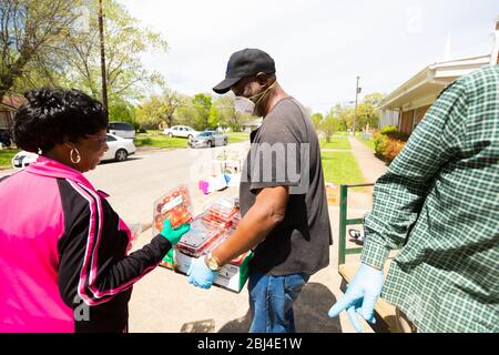 Sherman, TX / Vereinigte Staaten - 1. April 2020: Mitglieder der St. John's Christian Methodist Episcopal Church in Sherman, TX, veranstalten eine Drive-up-Speisekammer. Stockfoto