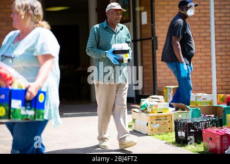 Sherman, TX / Vereinigte Staaten - 1. April 2020: Mitglieder der St. John's Christian Methodist Episcopal Church in Sherman, TX, veranstalten eine Drive-up-Speisekammer. Stockfoto