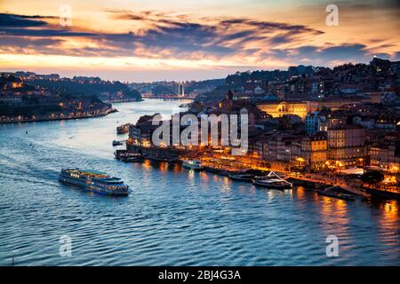 Porto, Portugal: Abendansicht von Porto Stadtbild und dem Douro Fluss mit traditionellen Rabelo Booten, von der Dom Luis Brücke nach Sonnenuntergang gesehen Stockfoto