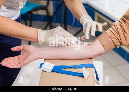 Covid-19, Pandemie und Viren Konzept - Nahaufnahme des Arztes nimmt Blut auf die Analyse. Stockfoto