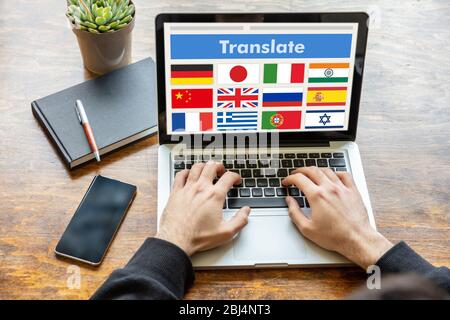 Online Translation, Fremdsprachen lernen Konzept. Mann bei der Arbeit mit einem Computer Laptop, Text auf dem Bildschirm übersetzen. Stockfoto