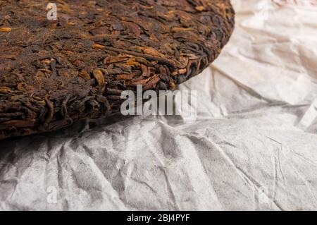 Chinesisch gepresster PU-erh Tee auf Geschenkpapier, Nahaufnahme Stockfoto
