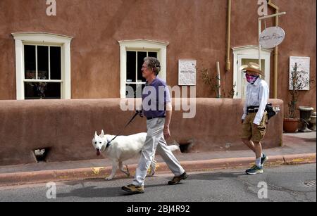 Zwei Männer, einer mit einer Coronavirus-Maske, gehen an einer Kunstgalerie in Santa Fe, New Mexico USA vorbei. Stockfoto