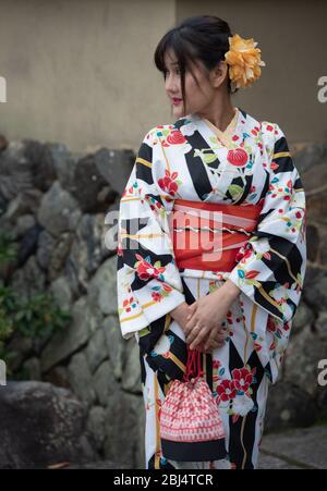 Eine japanische Frau, die mit einem traditionellen Kimono am Eingang zum Tenryuji-Tempel in Kyoto, Japan, gekleidet ist Stockfoto