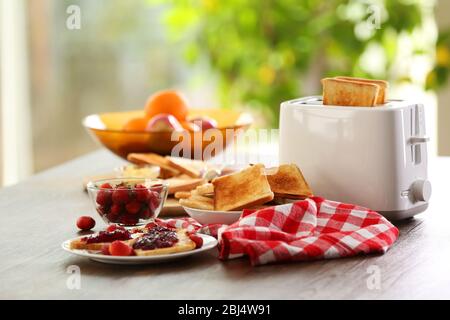 Tisch zum Frühstück mit Toast und Obst, auf verschwommenem Hintergrund Stockfoto