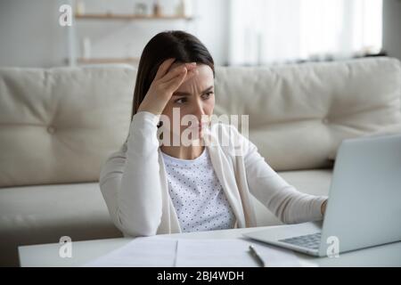 Unglückliche Frau durch langsame Internetverbindung auf Laptop betont Stockfoto