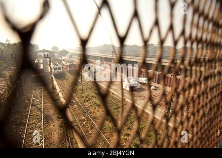 Blick durch einen Drahtzaun hinunter auf die Plattform des Hazrat Nizamuddin Bahnhof in Neu-Delhi in Indien. Stockfoto